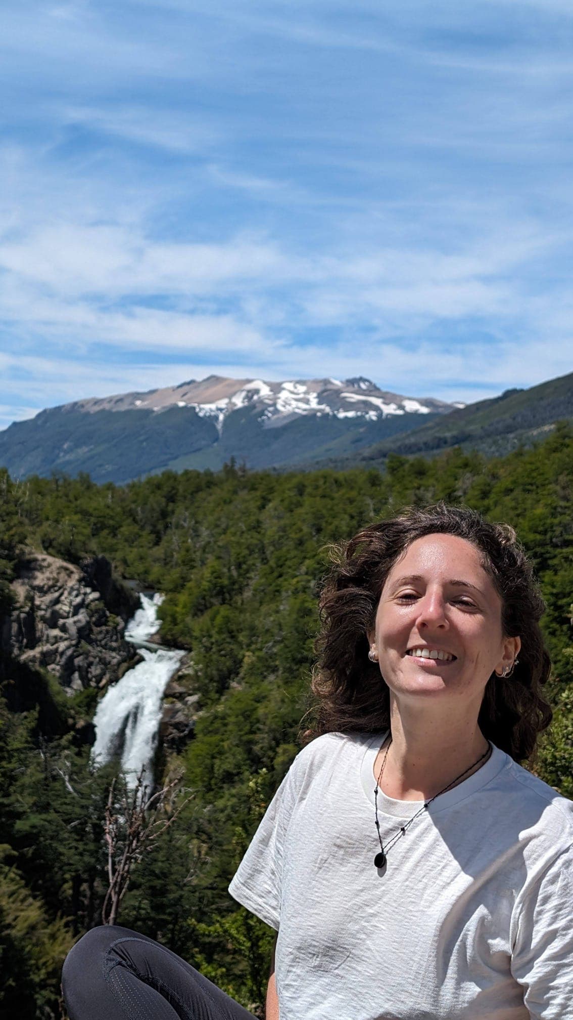 Yaëlle travelling, in front of a waterfall
